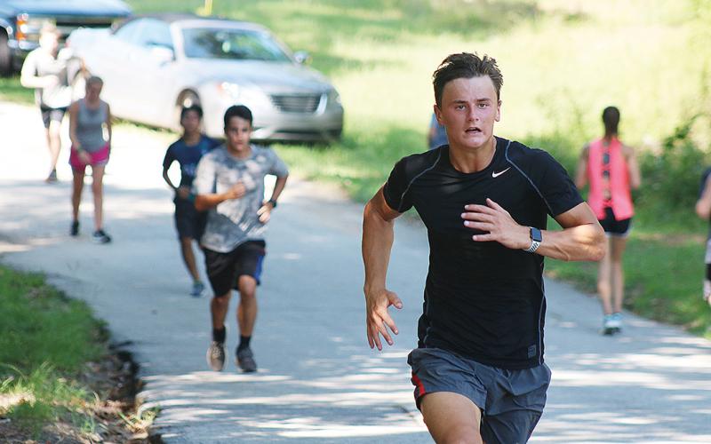 Sunshot by Grayson Williams — AJ Johnson runs up a hill recently at Hart County High School cross country practice. 