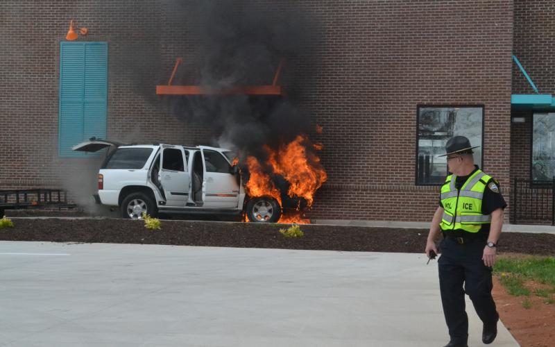 A car at the drive-thru window of Popeyes Chicken in Hartwell engulfed in flames Tuesday. The car, occupied by a family of five was picking up food when their vehicle caught fire. No one was harmed and the cause of the fire is unknown. 
