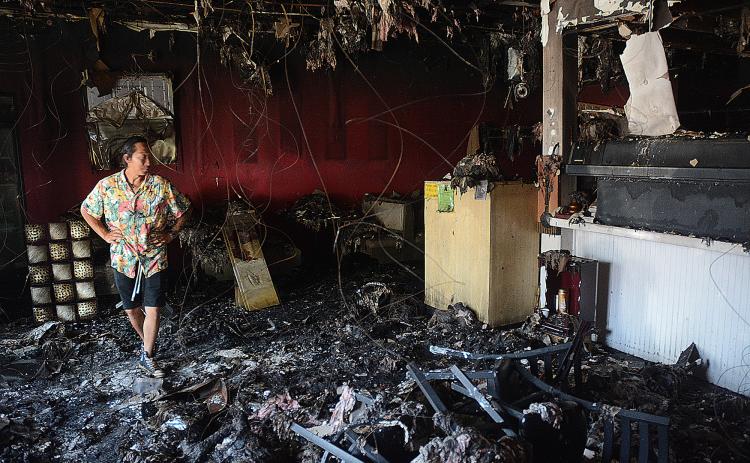 Sunshots by Michael Hall Little Japan co-owner Tommy Vang walks through the dining room and past the sushi bar at the restaurant on Tuesday as insurance adjusters assess the damages from an Aug. 9 fire.