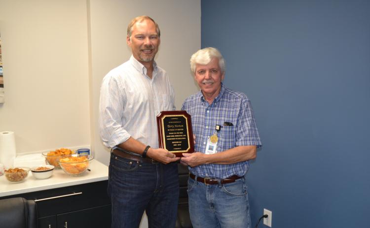 Terry Norton, right, retired this week after 50 years of service to Royston LLC. Norton was presented with a plaque commemorating his five decades of hard work by engineering manager Ben Credle, left.
