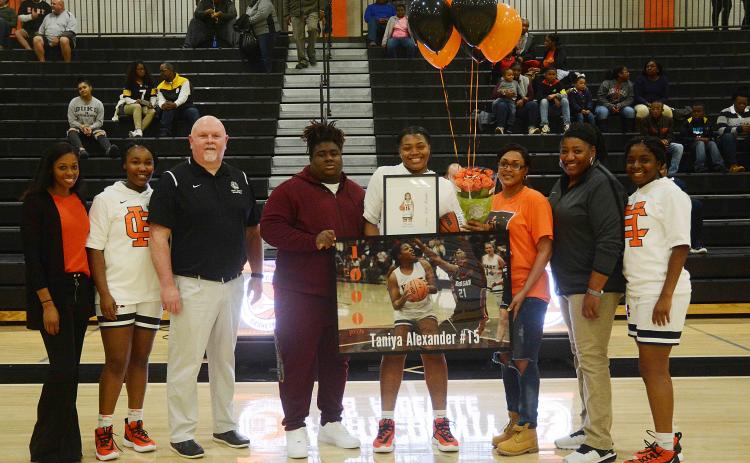 Sunshot by Michael Hall — Taniya Alexander, center, holds a poster and other items given to her to honor her for scoring 1,000 points for Hart County. Pictured are coach Joreshica Martin, Tanyzia Teasley, head coach Mike Edwards, Demardric Thornton, Alexander, her mother Tammy Scott, coach Dannette Bowers-Davis and Shakendra Grove. 