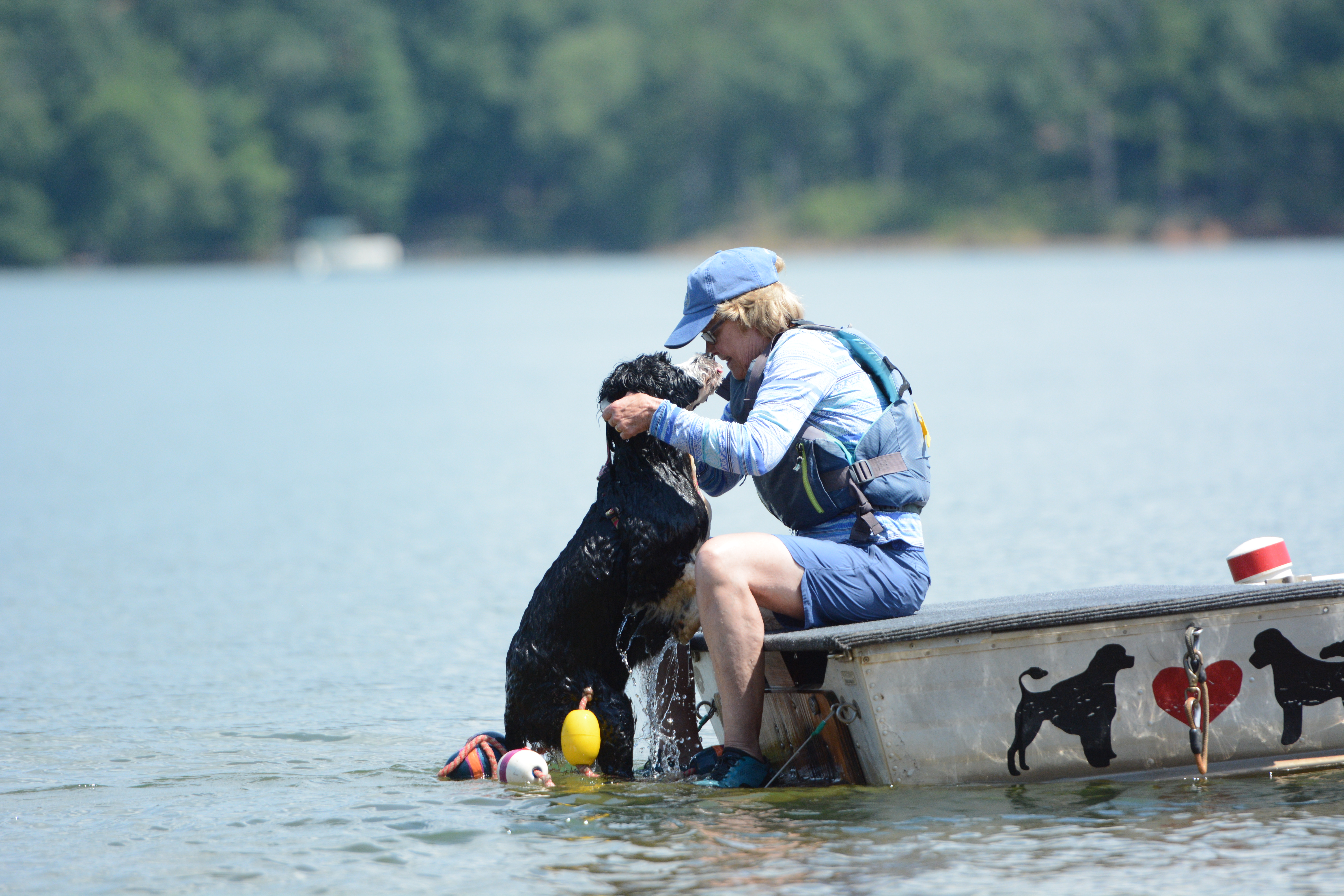 Diana Schaub, PWD trainer from Baltimore, Maryland, helps Zora, a 4-year-old female Master PWD, get back on the boat after performing tricks. (Photo/Adriana Cascio)
