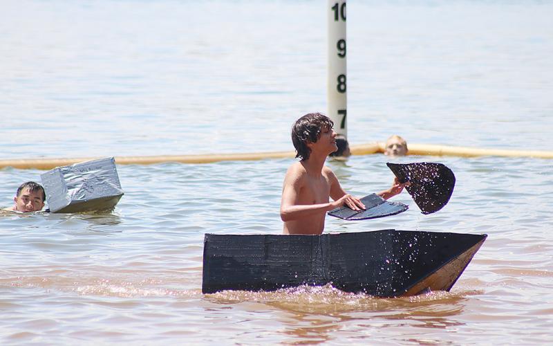 Daniel Mcelhannon paddles his boat made of cardboard and duct tape in Lake Hartwell at Elrod Ferry on July 24 during the annual Hart County High School band camp boat contest.