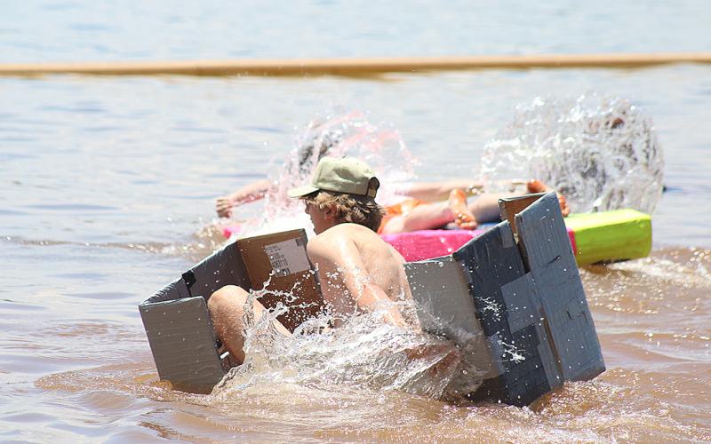 Luke Bennett tries fruitlessly to keep his makeshift boat afloat.