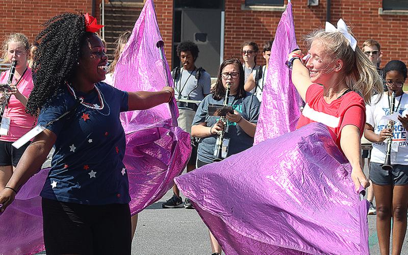 Flag corps members Detricunna Teasley, left, and Samantha Campbell, right, practice their flag routine during Hart County High School band camp on Monday.