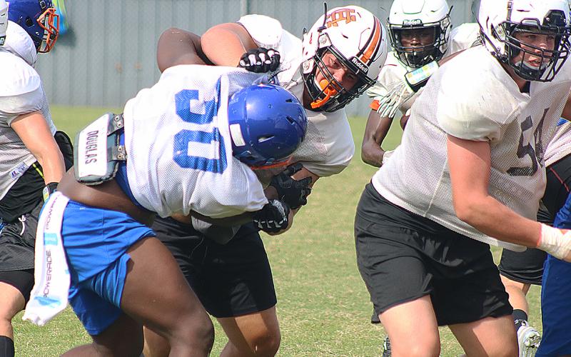 Hart County offensive lineman Caden Hart torques a Cedar Shoals defensive lineman last week at a full-contact camp in Habersham County.