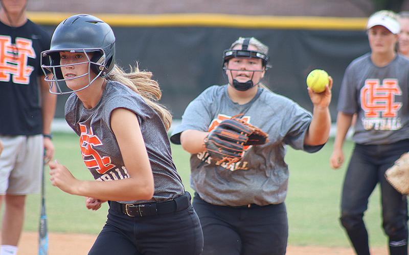Sunshot by Grayson Williams — Freshman Emilee Sanders, left, tries to escape a pickle during a drill at Hart County High School softball practice Monday as Hannah Segars, right, tries to get Sanders out.