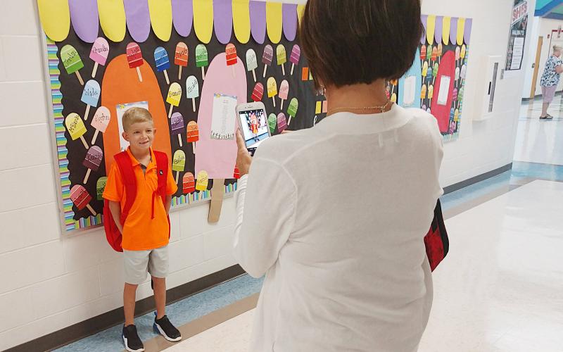 Second-grader Trooper Ayers gets his picture taken on the first day of school at South Hart Elementary on Aug. 1 by his mother Heather Ayers.