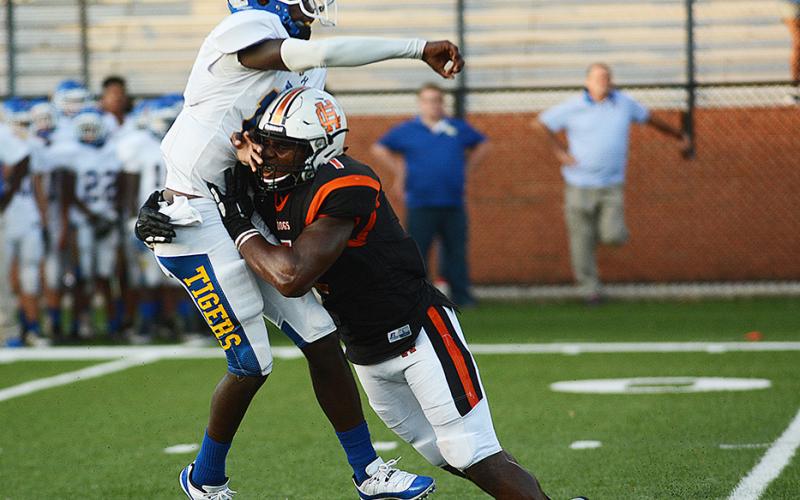 Sunshots by Grayson Williams — Defensive end Kaimon Rucker, above, hits the Tigers’ quarterback as he throws during the practice game.