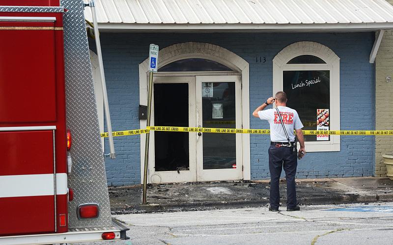 A Hartwell firefighter surveys the scene Friday morning at Little Japan.