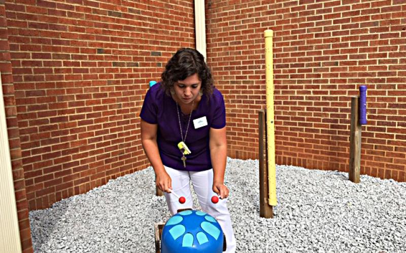 Photo submitted by Anna Hall — North Hart Elementary School music teacher Holly Fredericks plays her favorite addition to the school’s recently completed sound garden: a propane tank painted blue has been turned into a tank drum.