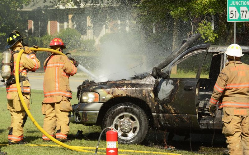 Sunshot by Michael Hall — Hartwell firefighters douse the engine bay of a Dodge Ram that caught fire Thursday in the parking lot of the old Bells Shopping Center.