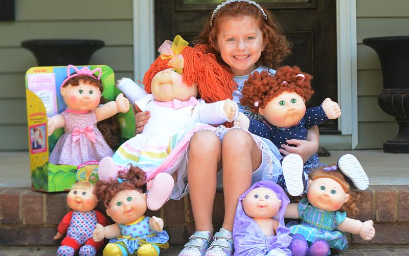 Sunshot by Michael Hall — Lainey Moon poses for a photo with her Cabbage Patch dolls, including the one she won in a look-alike contest she holds in her right hand.