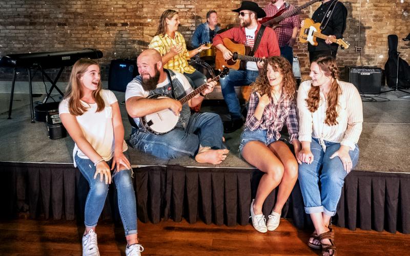 Sunshot by Bill Powell Pictured are Nash McCan and the McCan Family Band. Front row: Ella Long, Seth Howard, Victoria Evans amd Olivia Berry. Second row:  Andrea Bradford and Nash McCan (Josh Bryan). Back Row:  Kevin Long, Casey Middlebrooks and Jody DiMarco. Not Pictured: David Phillips and Jamee Floyd.