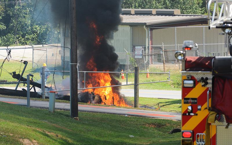 Sunshot by Michael Hall — A fire truck stands by while firefighters and police officers wait for power to be turned off to a burning power pole near Hart County High School on Tuesday.