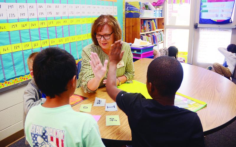 Sunshot by Michael Hall — Jenny Martin high-fives a second-grade student after he successfully identified a word in a reading exercise recently at Hartwell Elementary School.