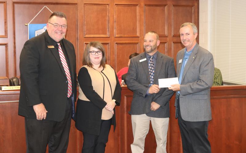Sunshot by Grayson Williams - Superintendent Jay Floyd, from left, and Hart County Board of Education chairperson Kim Pierce, pose for a photo with Hart College and Career Academy CEO Brooks Mewborn as Mewborn accepts a donation from Georgia Power’s Kevin McCraney to help fund an aerodynamics lab at the academy.