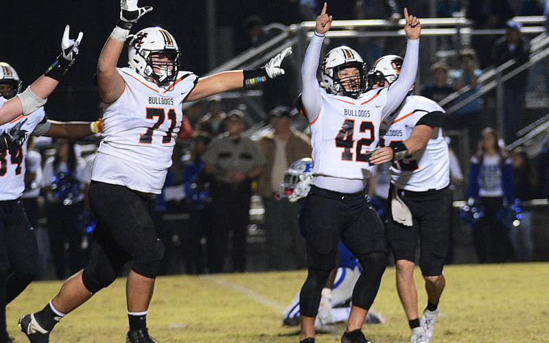 Sunshot by Michael Hall - Hart County kicker Tucker Kim, No. 42, raises his hands in victory along with Caden Hart, No. 71, while quarterback Luke Lee tackles Kim after Kim’s game winning field goal on Nov. 22 in Blackshear over the Pierce County Bears.