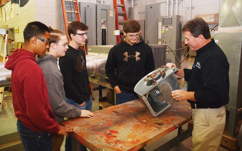 Sunshot by Michael Hall - McGee Heating and Air president Robert Kesler, right, talks to students at the Hart College and Career Academy this week about how a central HVAC system works.