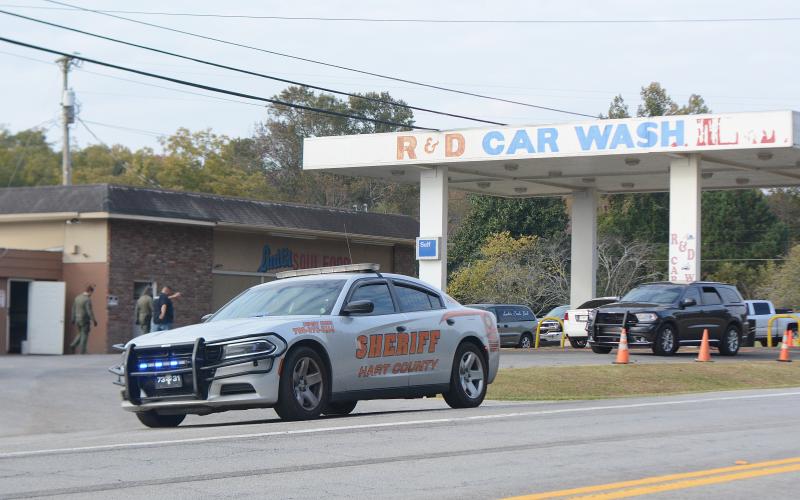 A Hart County deputy's car is parked at the entrance of R&amp;D Car Wash on Anderson Highway as the GBI and other authorities investigate an alleged racketeering scheme they believe involves Hart County commissioner R.C. Oglesby.