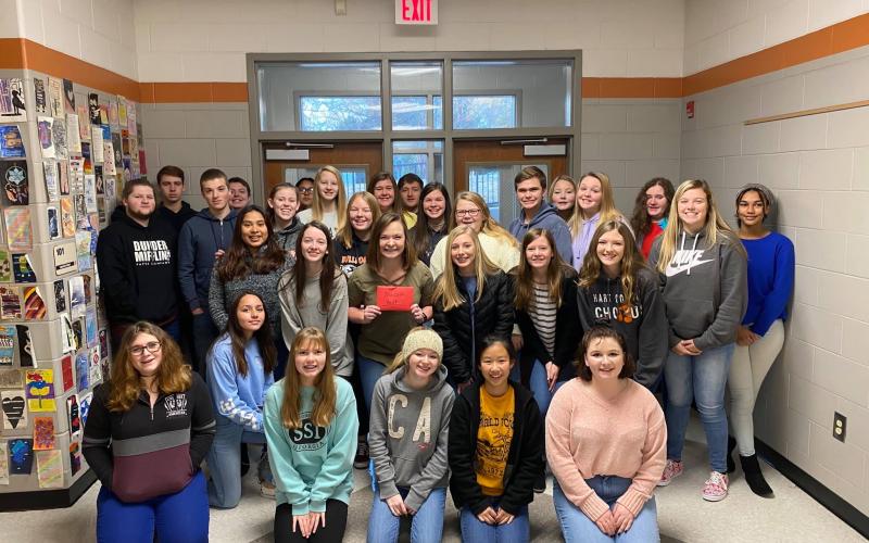 Photo submitted - Corrina Crumpton, in the middle holding an envelope, received tickets to swim with whale sharks at the Georgia Aquarium from her class after the students learned of her wish.