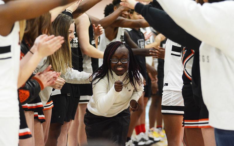 Sunshots by Grayson Williams — Briamah Edmond runs under an arch of hands made by basketball players and cheerleaders at Buddy Basketball on Dec. 16 at Hart County High School.
