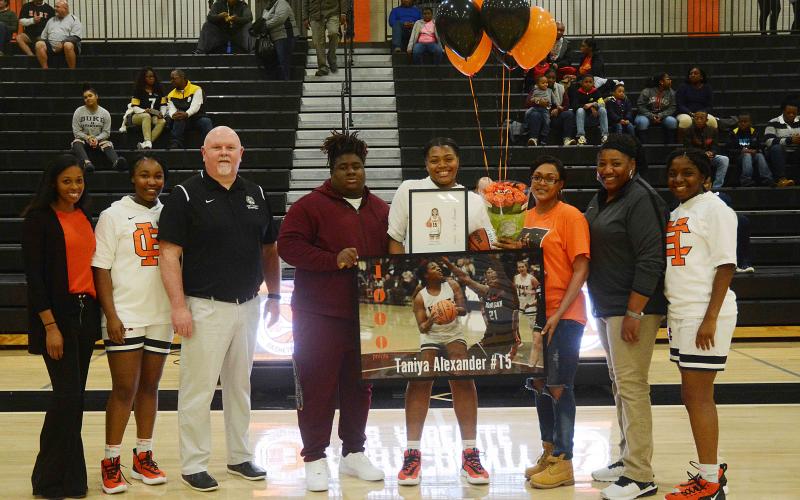 Sunshot by Michael Hall — Taniya Alexander, center, holds a poster and other items given to her to honor her for scoring 1,000 points for Hart County. Pictured are coach Joreshica Martin, Tanyzia Teasley, head coach Mike Edwards, Demardric Thornton, Alexander, her mother Tammy Scott, coach Dannette Bowers-Davis and Shakendra Grove.