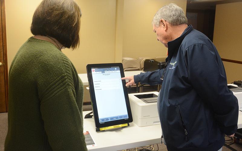 Hart County Board of Elections supervisor Robin Webb, left, and Paul Bishop, a poll worker, demonstrate how the new Dominion voting machines operate much like an iPad when casting votes.