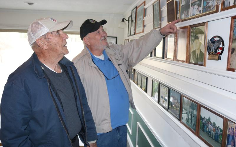 Sunshot by Grayson Williams - American Legion Post 109 members Charles Howard, left, and Sidney Reed, right, look at pictures on the wall at the Post’s clubhouse in Hartwell.