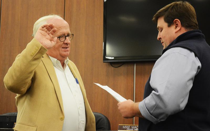 Sunshot by Michael Hall - New Hartwell city councilman Stephen “Doc” Ayers, takes his oath of office, administered by city manager Jon Herschell, at the first city council meeting of the year on Jan. 6.