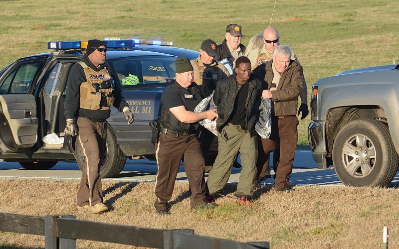 Sunshot by Michael Hall - Hart County Sheriff Mike Cleveland, right, and deputies escort Larrendrick Rashad Tabor, center, from a squad car to an ambulance after his arrest Tuesday, Jan. 28, for his alleged involvement in a Monday night murder in Hart County.