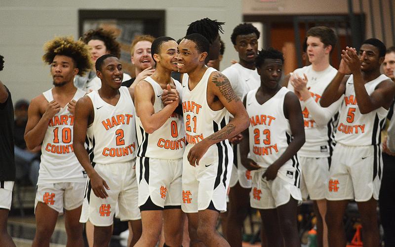 Sunshots by Grayson Williams - Junior Shone Webb, No. 21, is all smiles as he shakes hands with Demetrius Glenn, No. 0, as his Bulldog teammates congratulate him on scoring his 1,000th point for Hart County.