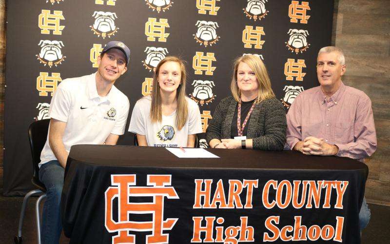 Sunshot by Grayson Williams Jillian Hoell second from left, signed on Jan. 31 to run cross country at Reinhardt University next season. Pictured are Reinhardt coach Jordan Turner, Hoell, her mother Sarah Hoell and father Roy Hoell.