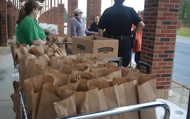 A cart full of prepared bagged lunches wait to be passed out to families as part of a program through the Hart County Charter System to provide lunches during the school closure due to the coronavirus pandemic.