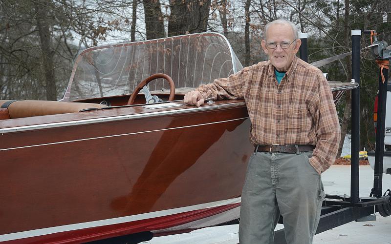 Sunshots by Michael Hall -  Lee Mapp poses for a photo next to his Correct Craft classic boat.