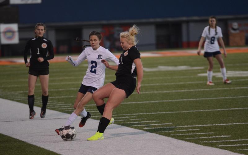 Sunshot by Grayson Williams - Skyler Chastain, right, battles for the ball with an East Jackson player on Friday, March 6 at Herndon Stadium as Evelyn Holmes, left, approaches.