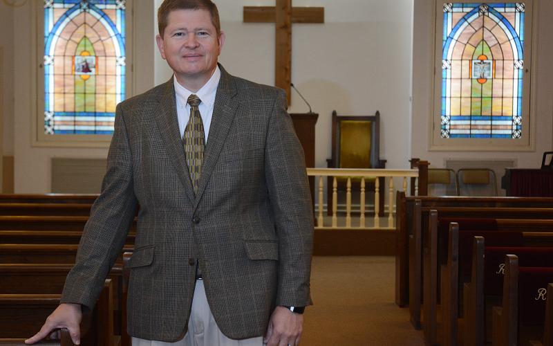 Sunshot by Michael Hall — Funeral director Arnold Strickland of Strickland Funeral Home stands in the empty chapel at his Hartwell location where funeral services are few and far between these days because of social distancing requirements issued by national, state and local governments.