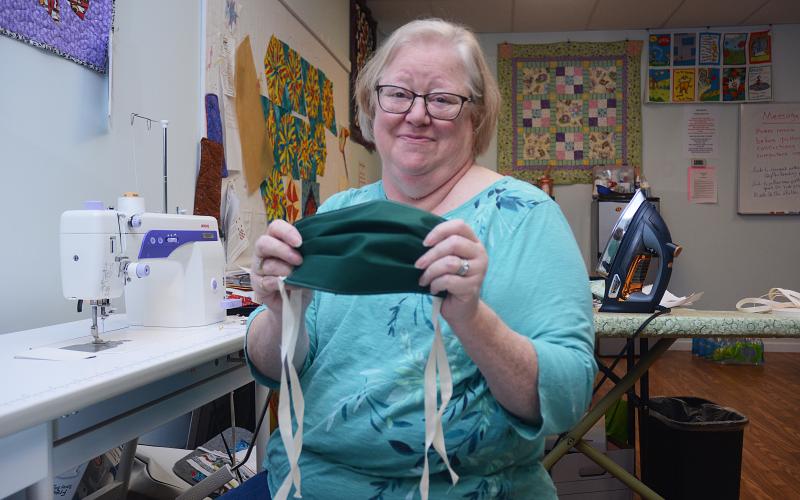 Sunshot by Michael Hall — Annie Dunn, owner of Annie’s Pretty Pieces, shows off a mask in progress at her store last week in Hartwell.