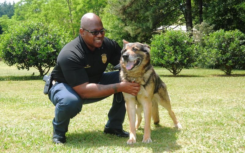 Sunshot by Michael Hall — Hartwell Police investigator Sherod Blackwell pets Justice, the recently retired K-9 unit Blackwell handled for all of Justice’s years of service to the department. Justice now lives with Blackwell as a pet.