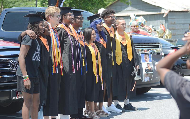 A group of graduates pose for photos taken by parents, family and friends prior to the parade leaving the parking lot of Hart County High School.