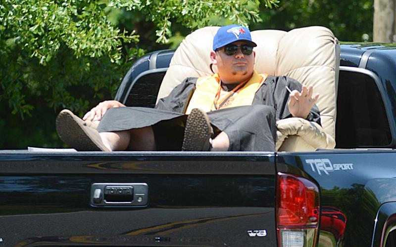 Caden Hart relaxes in a recliner in the back of a truck as the parade rolls down Campbell Drive on May 23.