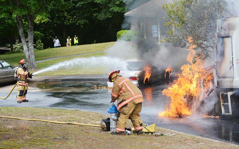 Sunshot by Michael Hall — Hartwell firefighters try put out a garbage truck and car on fire at Woodlake Apartments on Thursday.