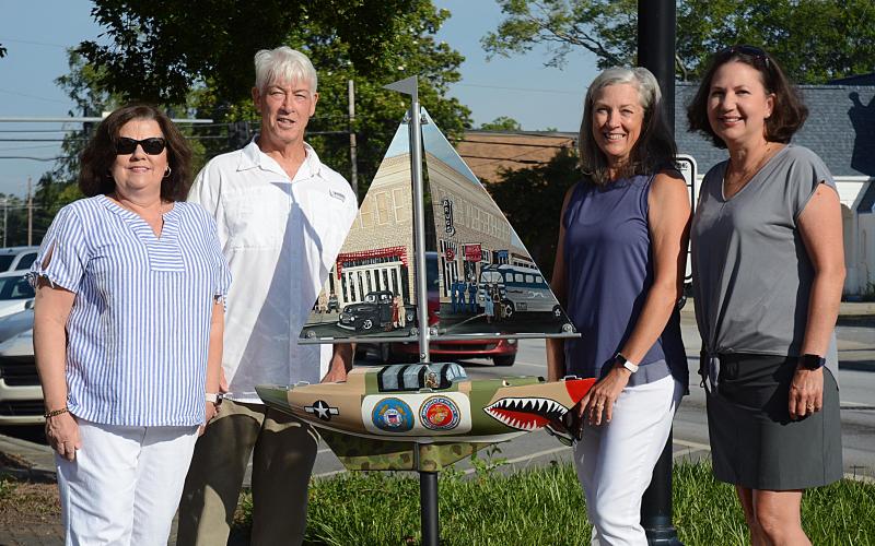 Sunshots by Michael Hall — From left to right, artist Debbie Gurley, Bo Howard, Tina Howard and artist Angela Short pose for a photo with the new sailboat installed Wednesday at Carolina and Howell streets to honor where service members boarded buses to go to World War II. The Howards spearheaded the fundraising for the project.