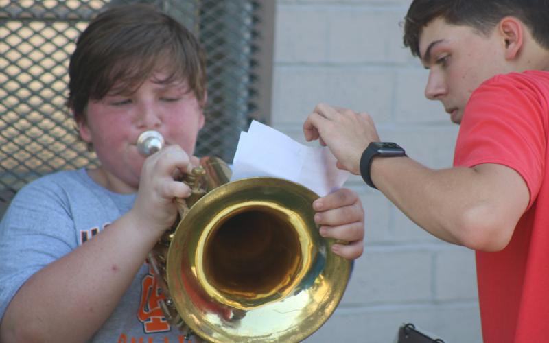 Sunshots by Grayson Williams — Hart County High School band captain Adam Walters, right, helps Caleb Reed, left with his music during the second day of band camp on Tuesday.