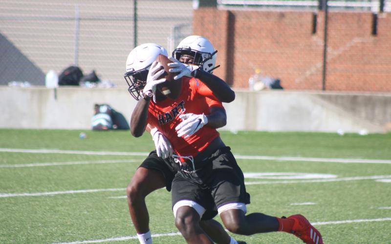 Sunshot by Grayson Williams — Receiver Paul Davis pulls down a catch and battles a defender Monday, July 27, at Herndon Stadium during Hart County football practice.