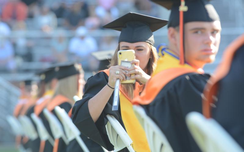 Demy NeSmith takes a photo of the crowd from her socially distanced seat on the field at Herndon Stadium prior to the 2020 Hart County High School graduation ceremony on Saturday, July 28.
