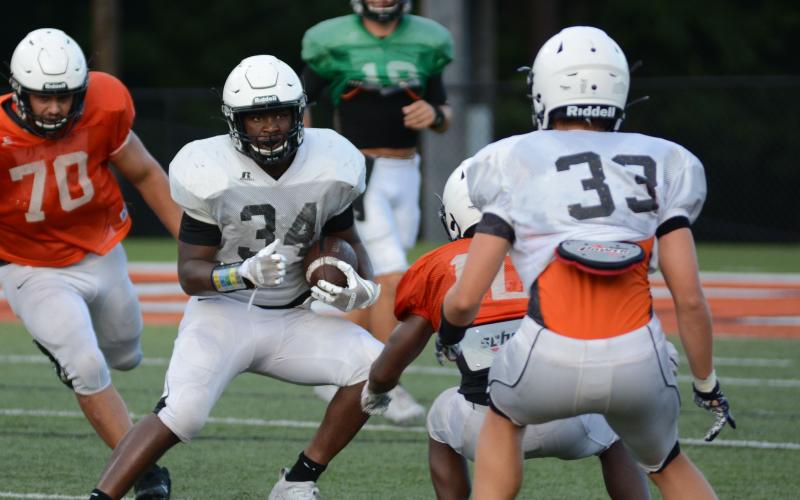 Sunshot by Grayson Williams - Running back J.L. Lackey carries the football during Hart County’s intrasquad scrimmage on Friday, Aug. 21, at Herndon Stadium.