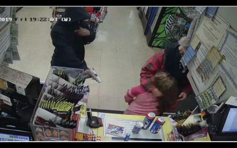 Photo submitted — This image taken from surveillance footage and posted on social media by Parks White shows a man pointing a pistol at a young girl during an armed robbery at a local Jimbo’s convenience store on Dec. 6, 2019.