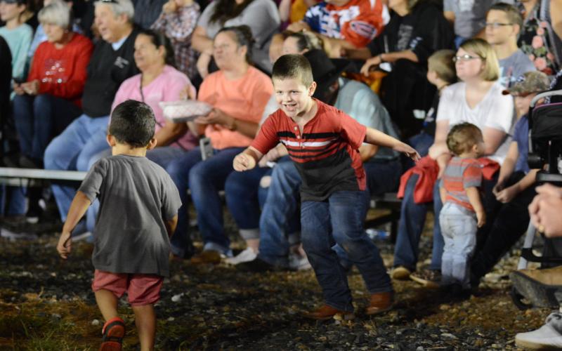 Children play like a bull and a bullfighter on Saturday, Sept. 26, during a short bullfighting break by the professionals before the final round.