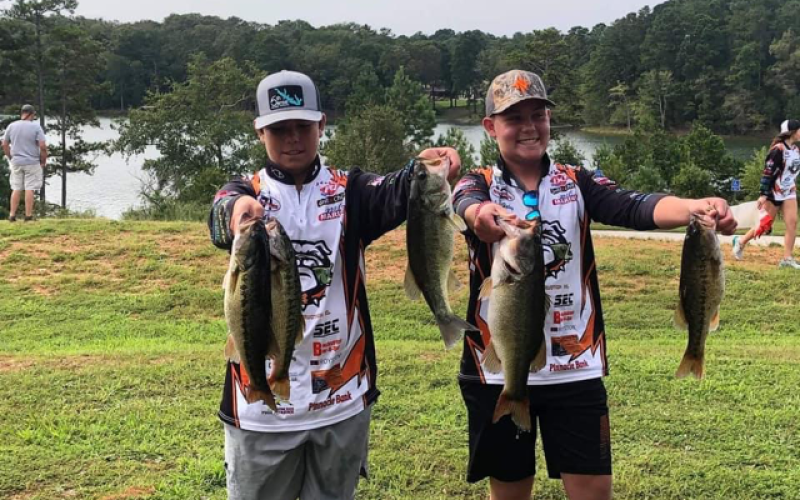 Jacob Fowler, left, and Joshua Haley, right, show off their catches following an intra-club tournament on Lake Hartwell.